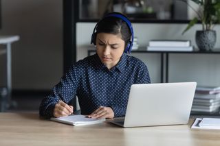 Frau macht sich Notizen während eines Gesprächs